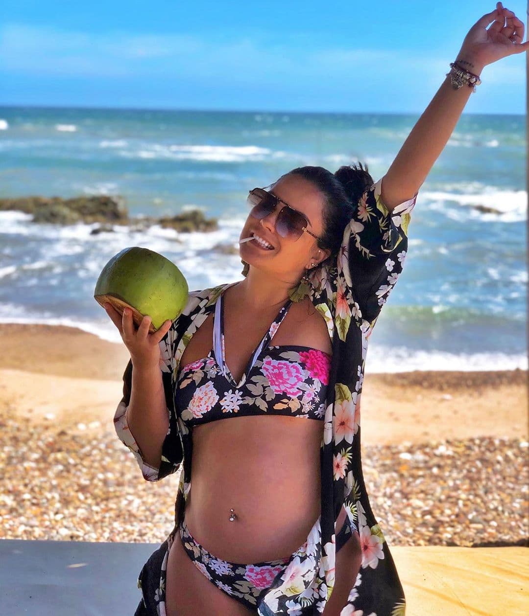 Mariana Echeverría, una de las hermanas de la Familia Disfuncional, está embarazada y se fue a la playa a descansar, además ha compartido un par de fotos de su pancita. Aquí la vemos disfrutando un coco y el mar, con un bikini de flores y lentes.