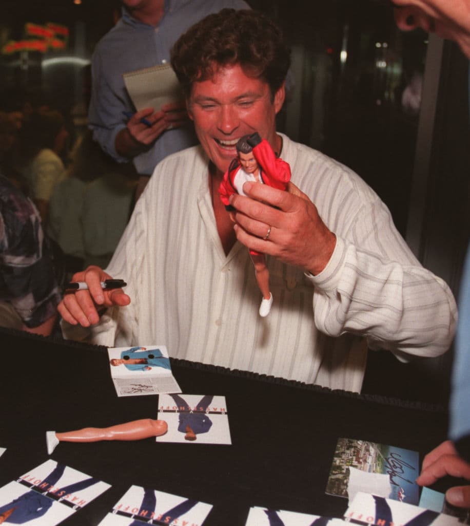 En esta foto se ríe mientras se prepara para autografiar una figura de acción de él mismo. La pierna de la muñeca se desprendió después de la firma. Hasselhoff estaba promocionando su nuevo álbum, "David Hasselhoff" cantando y firmando autógrafos.