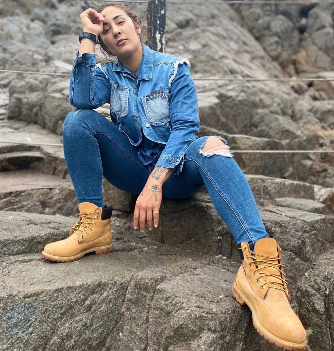 La mezclilla es una de sus prendas favoritas y sabe cómo combinarla a la perfección con estas botas color beige durante su visita a La Bufadora, Ensenada.