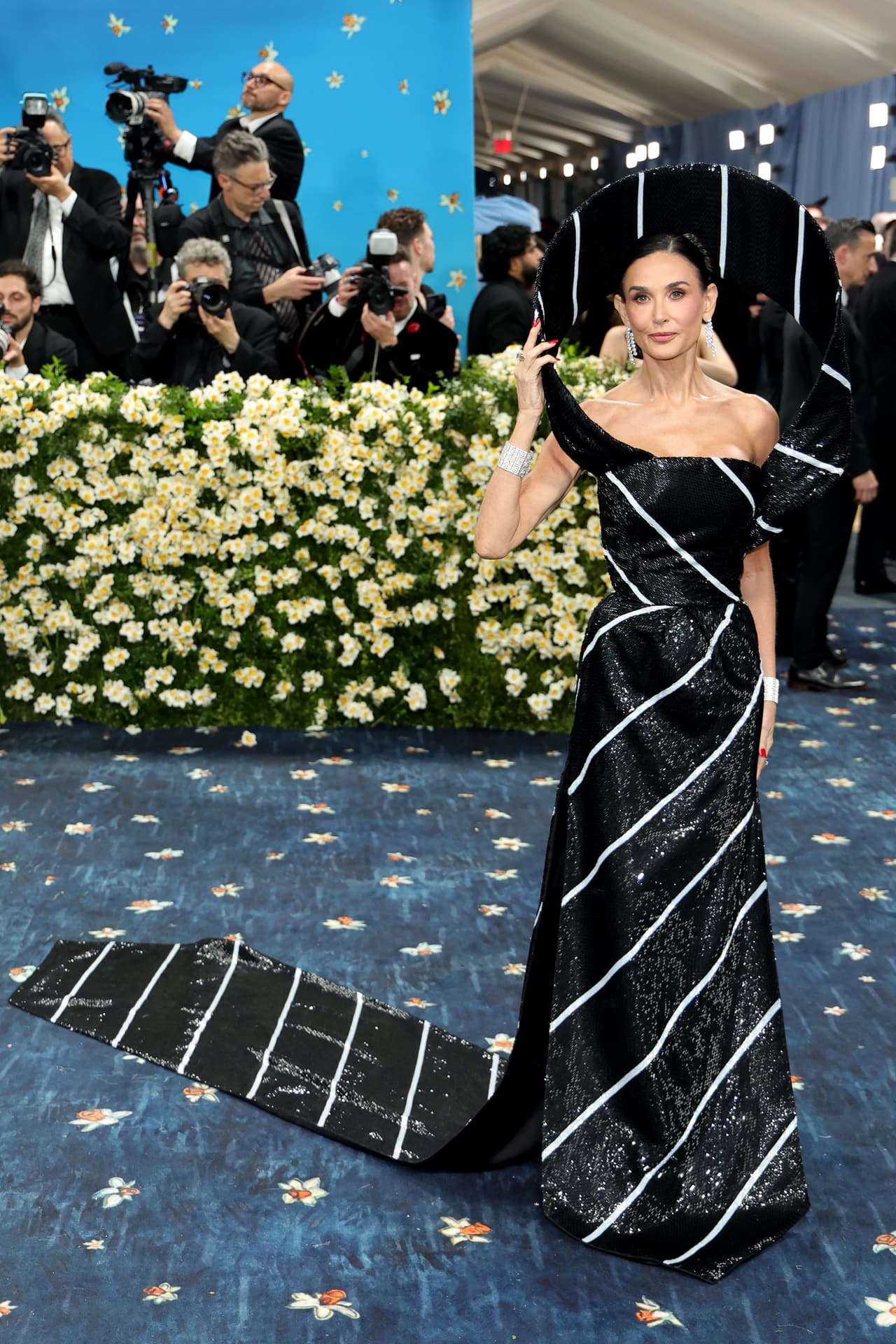 Demi Moore asistió a la celebración con un vestido blanco y negro que dejaba al descubierto sus hombros. Aparentemente, la figura que la creación formaba es una corbata.