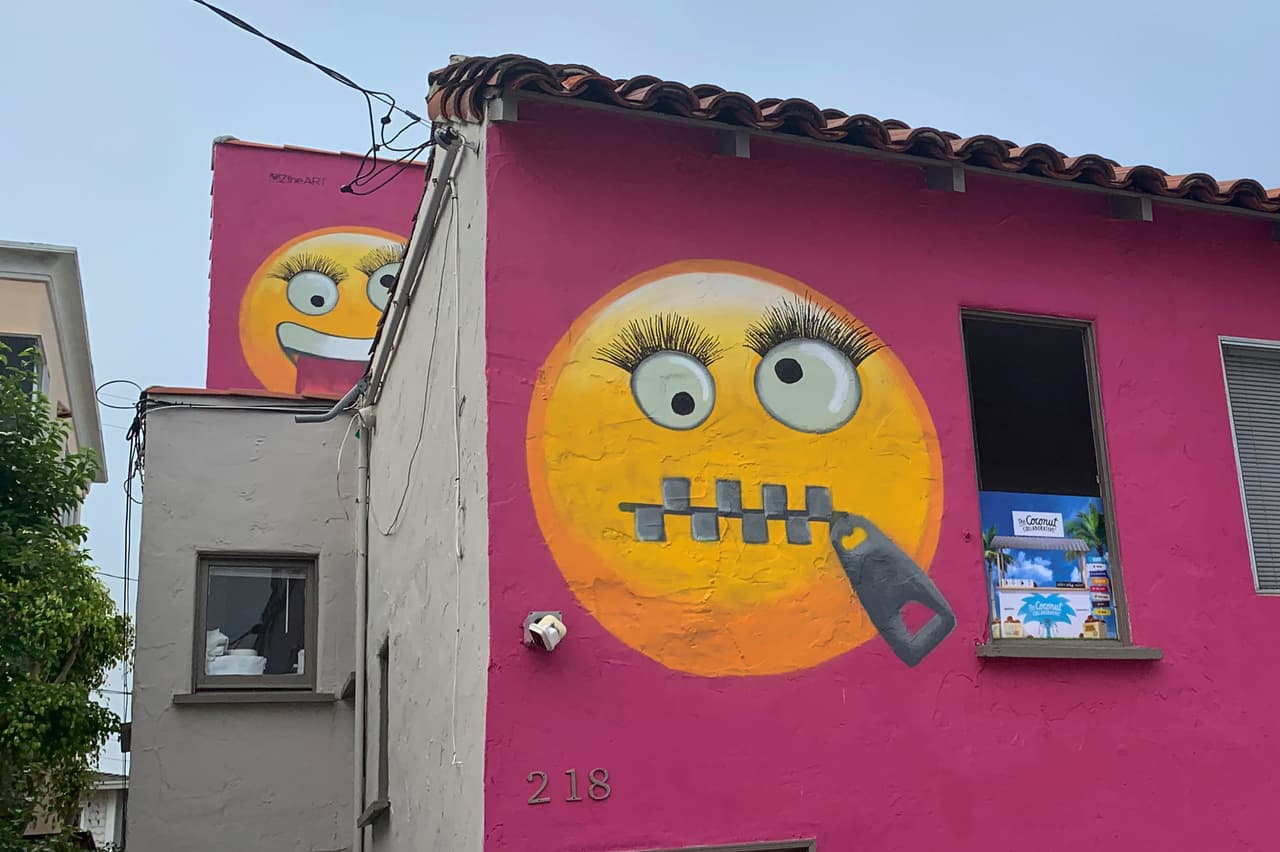 Painted emoji are seen on a house in Manhattan Beach, Calif. on Wednesday, Aug. 7, 2019. The Southern California seaside community is in an uproar after the home was given the new paint job featuring two huge emojis on a bright pink background. Manhattan Beach residents railed against the makeover during a City Council meeting Tuesday night, citing problems with spectators. (AP Photo/Natalie Rice)