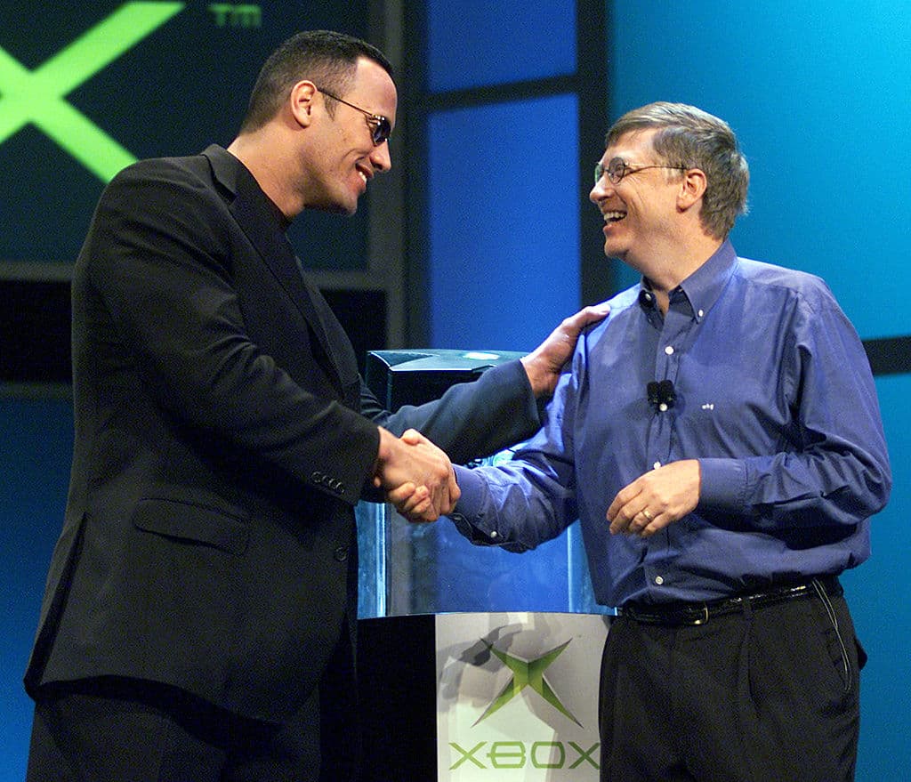Más diversión: Bill Gates, presidente y jefe de Microsoft, le da la mano a la entonces estrella de la World Wrestling Federation "The Rock" después de que Gates presentara la nueva consola de videojuegos Xbox el 6 de enero de 2001, durante su discurso de apertura en el Consumer Electronics Show en Las Vegas.