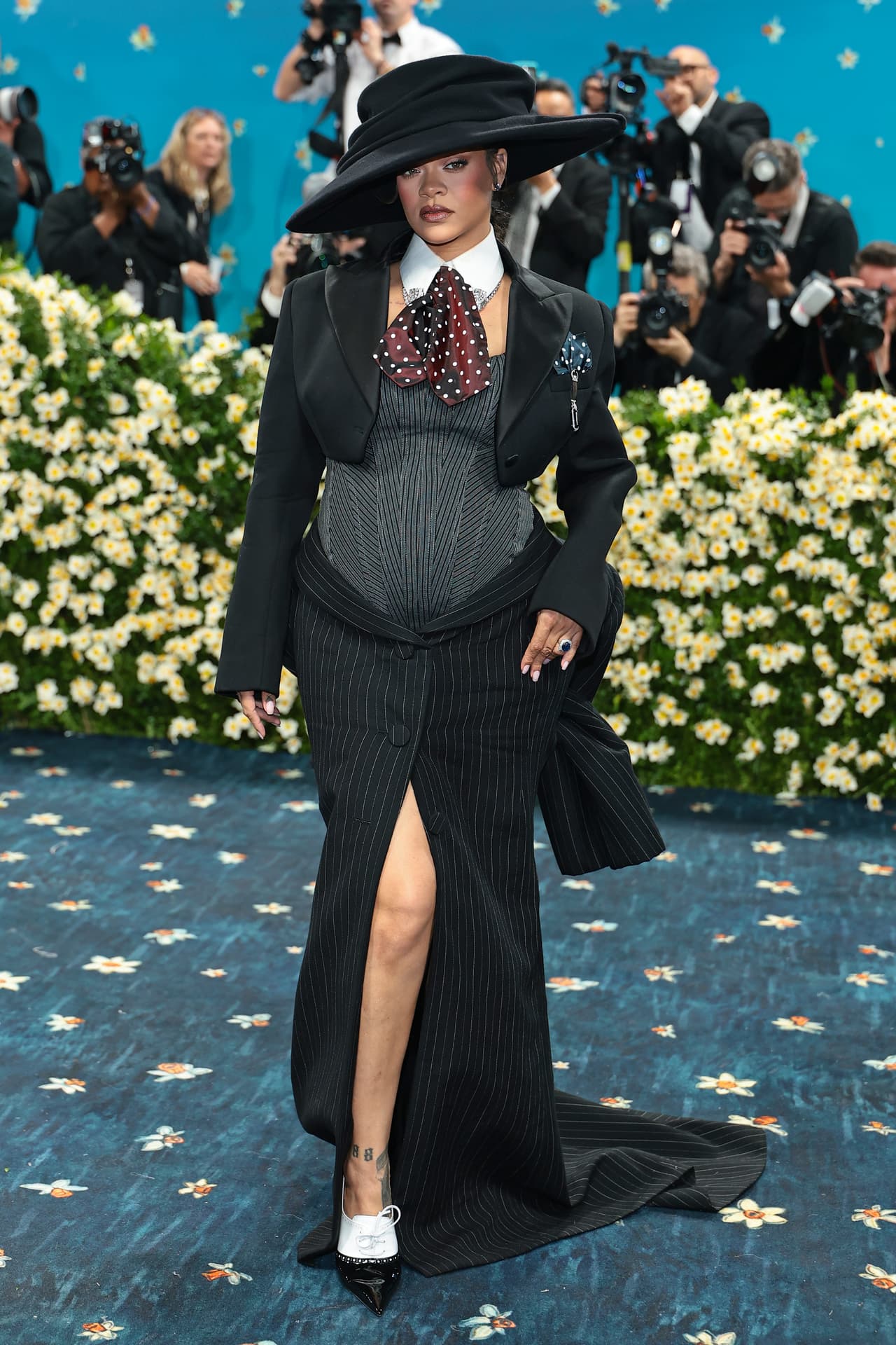 Rihanna optó por un tuxedo diseñado por Marc Jacobs con el que 
<a href="https://www.univision.com/famosos/rihanna-embarazada-met-gala-2025">lució su pancita de embarazo</a>.