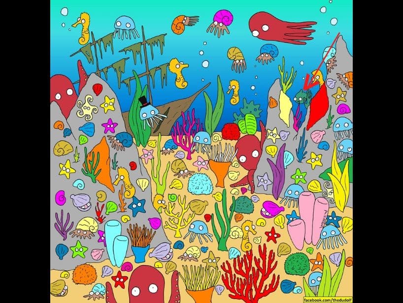 El pez está entre las dos piedras de la derecha; es color verde.